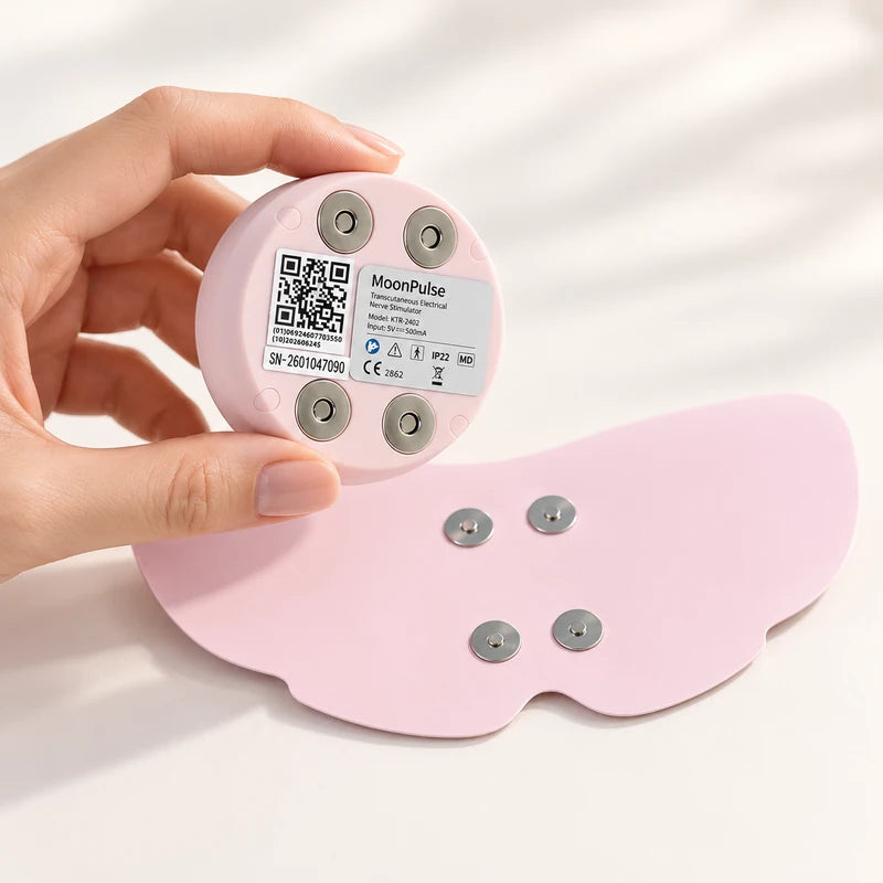 MoonPulse FDA-cleared TENS device with built-in heat held above its pad to show the connectors