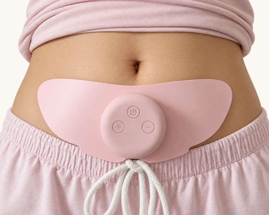 MoonPulse device with both pad wings worn on the lower abdomen, above pink lounge pants